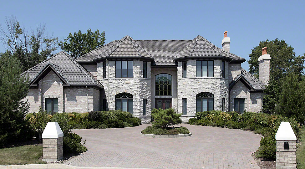 10537578 – large stone home with pillars and brick driveway