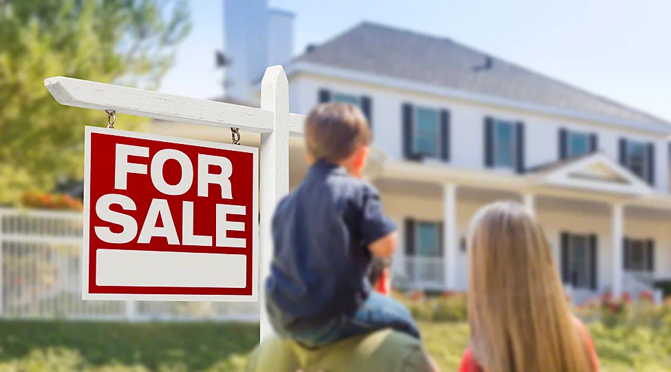 Curious Family Facing For Sale Real Estate Sign and Beautiful New House.