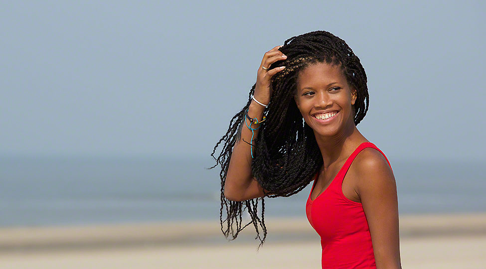 Beautiful young black woman smiling at the beach