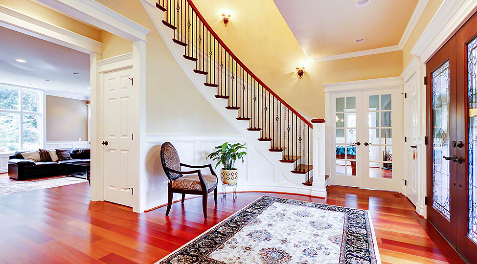Luxury home entrance with cherry hardwood floor and staircase.