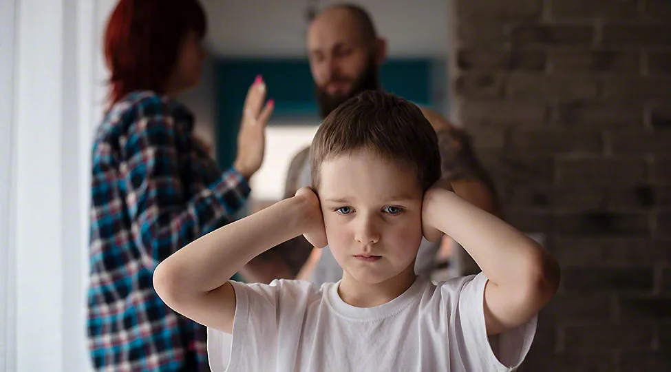 Sad, desperate little boy during parents quarrel
