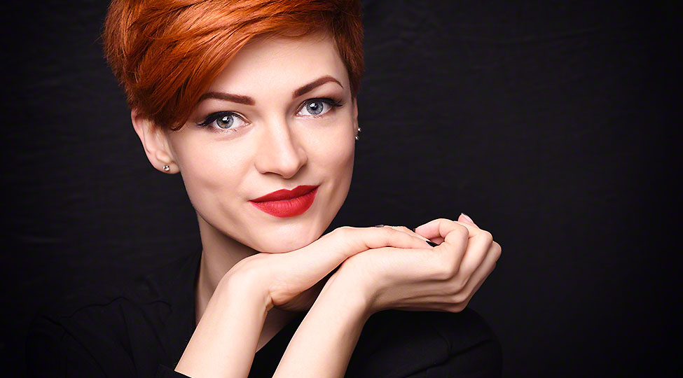 Portrait of a beautiful young red-haired woman with short hair o