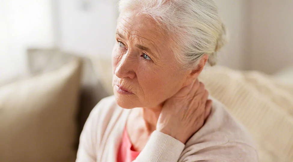 senior woman suffering from neck pain at home