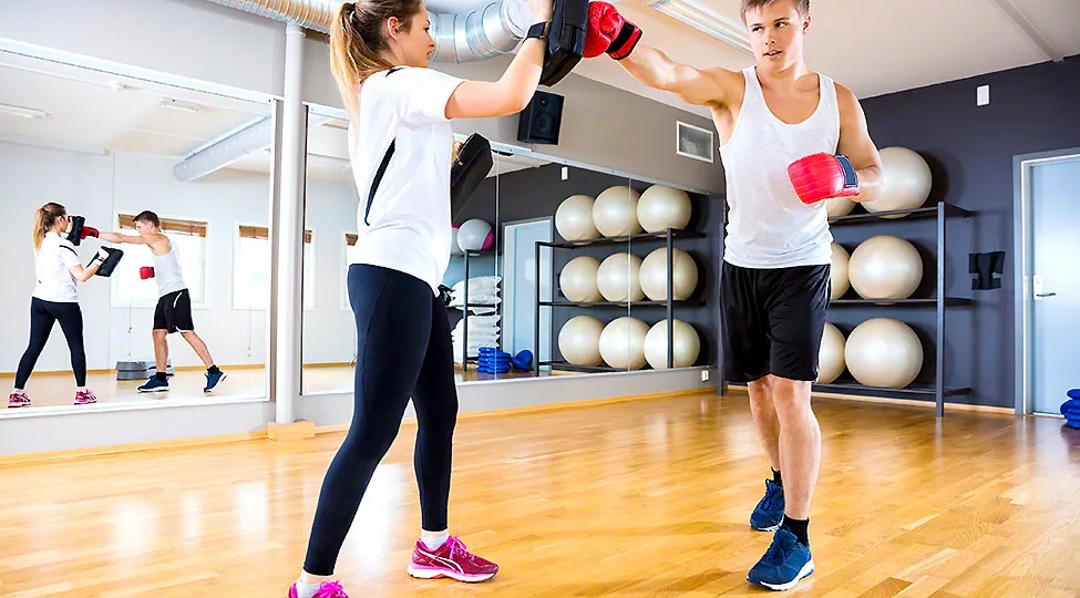 Two focused people training boxing at the fitness gym