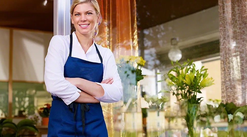 Young pretty woman working as florist in shop and smiling